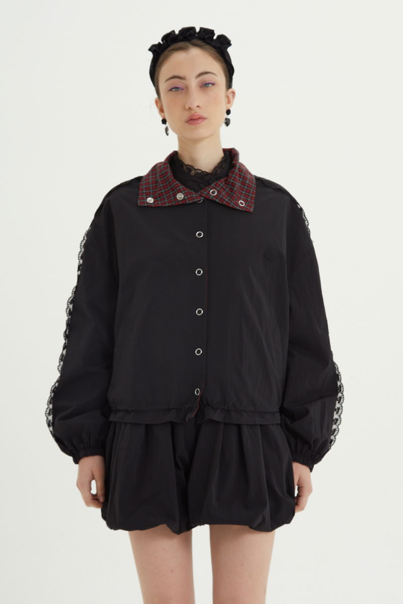 Campera reversible con puntilla y motivo de cuadros, cuello alto, broches snap y cintura con tancas. 
