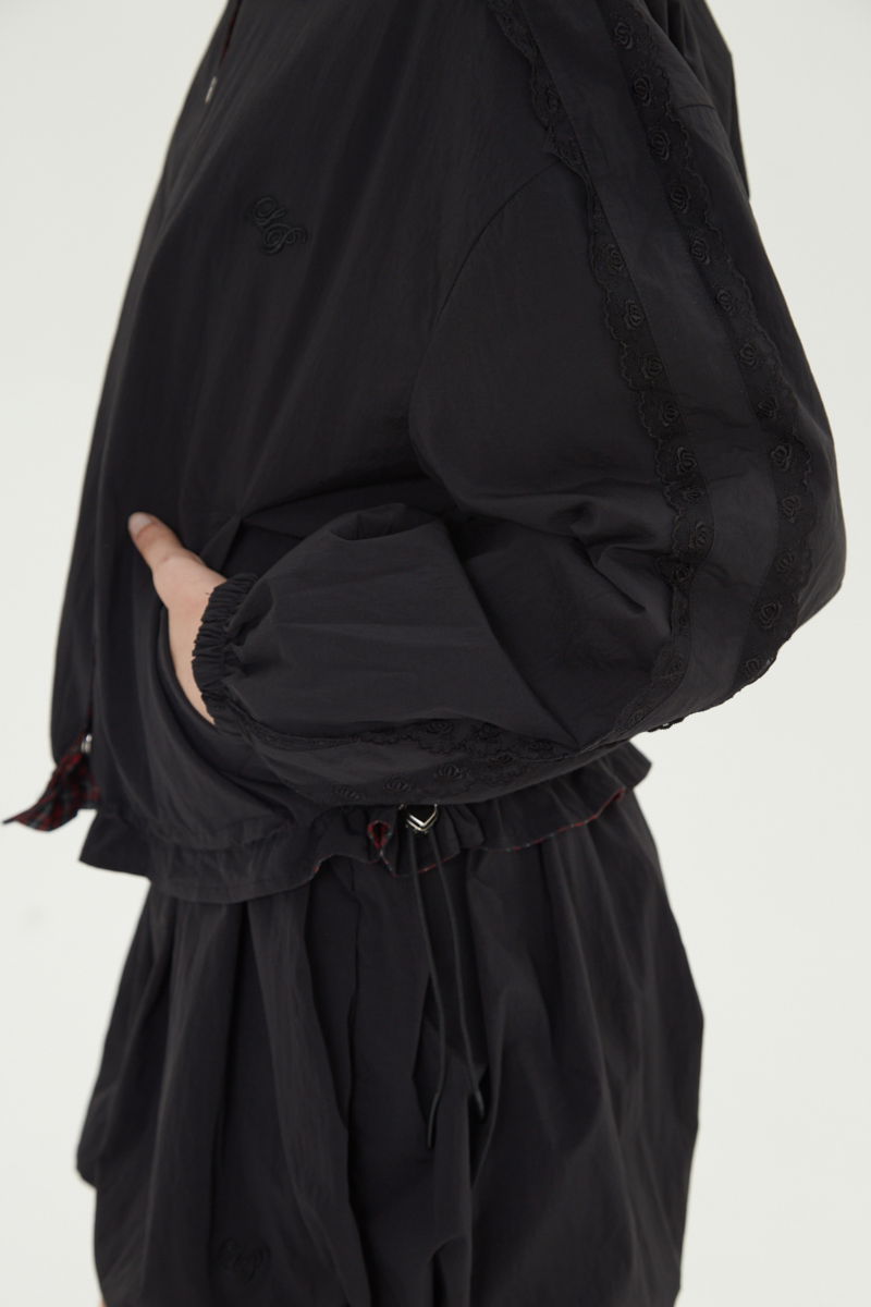 Campera reversible con puntilla y motivo de cuadros, cuello alto, broches snap y cintura con tancas. 
