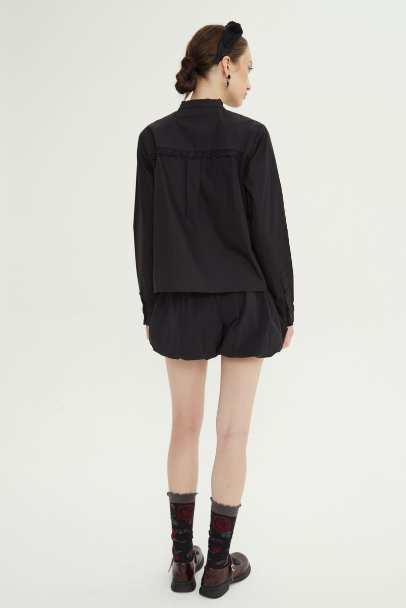 Camisa negra de algodón recta con cuello mao y terminaciones de encaje en cuello, puños, cartera y canesú. 