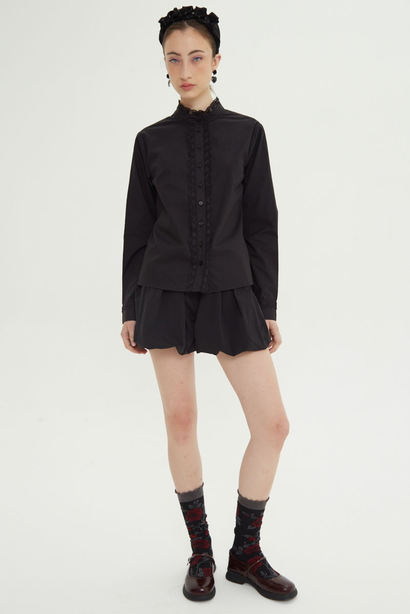 Camisa negra de algodón recta con cuello mao y terminaciones de encaje en cuello, puños, cartera y canesú. 