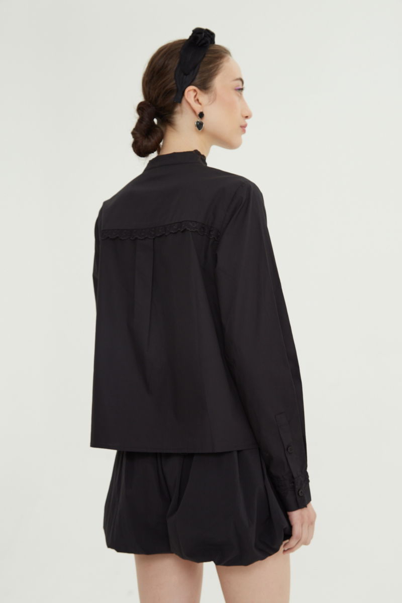 Camisa negra de algodón recta con cuello mao y terminaciones de encaje en cuello, puños, cartera y canesú. 