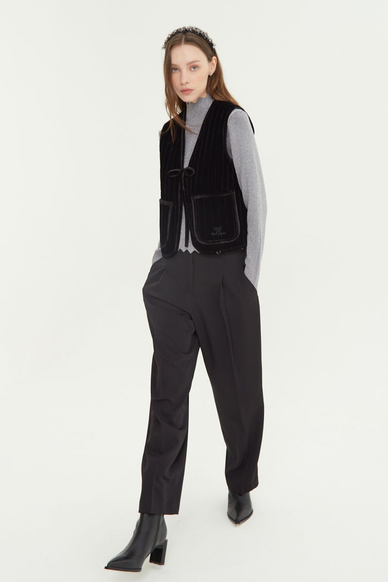 Pantalón negro sastrero tiro alto, de corte recto y largo hasta los tobillos con pinzas de entalle en frente y espalda. 