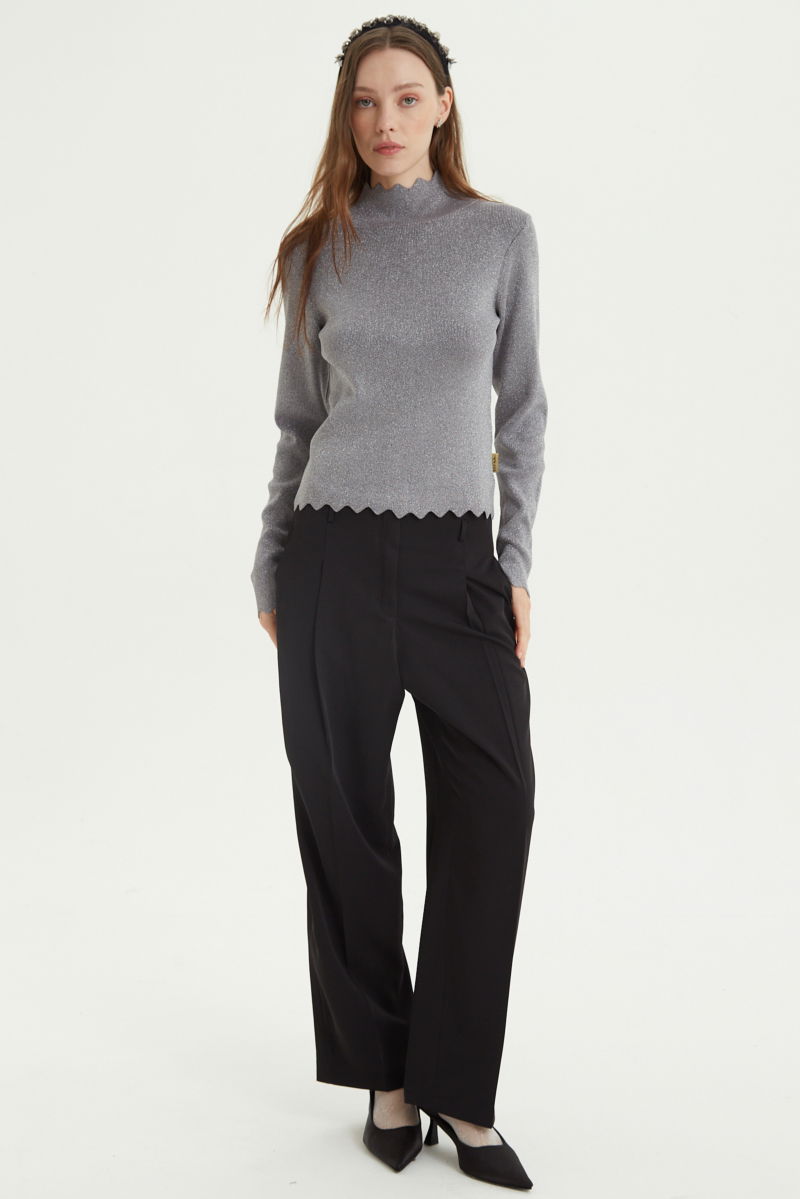 Pantalón negro sastrero tiro alto, de corte recto y largo hasta los tobillos con pinzas de entalle en frente y espalda. 