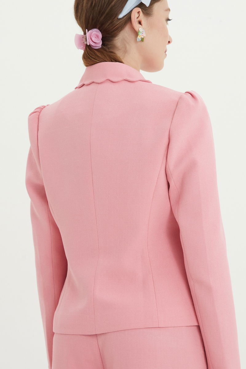 Blazer rosa sastrero entallado con terminación ondulada y mangas princesa. 
