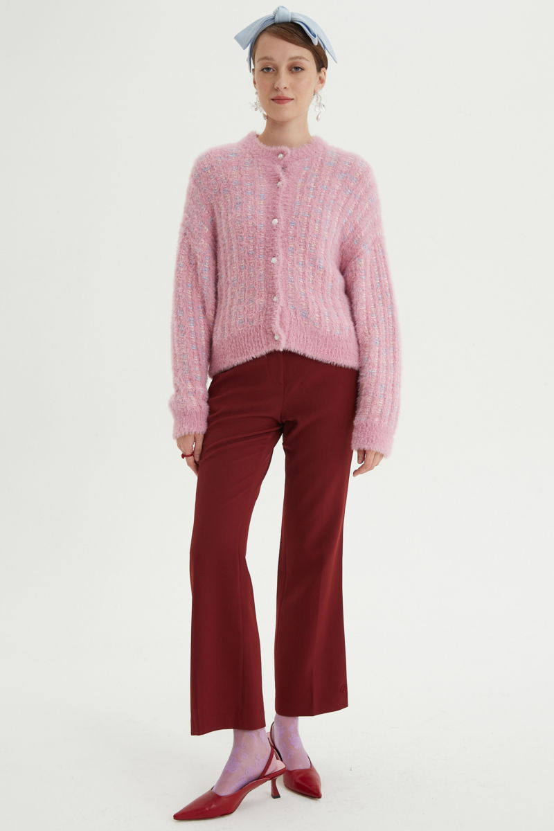 Saco tejido multicolor con textura de pelo y botones perlados en forma de flor. 
