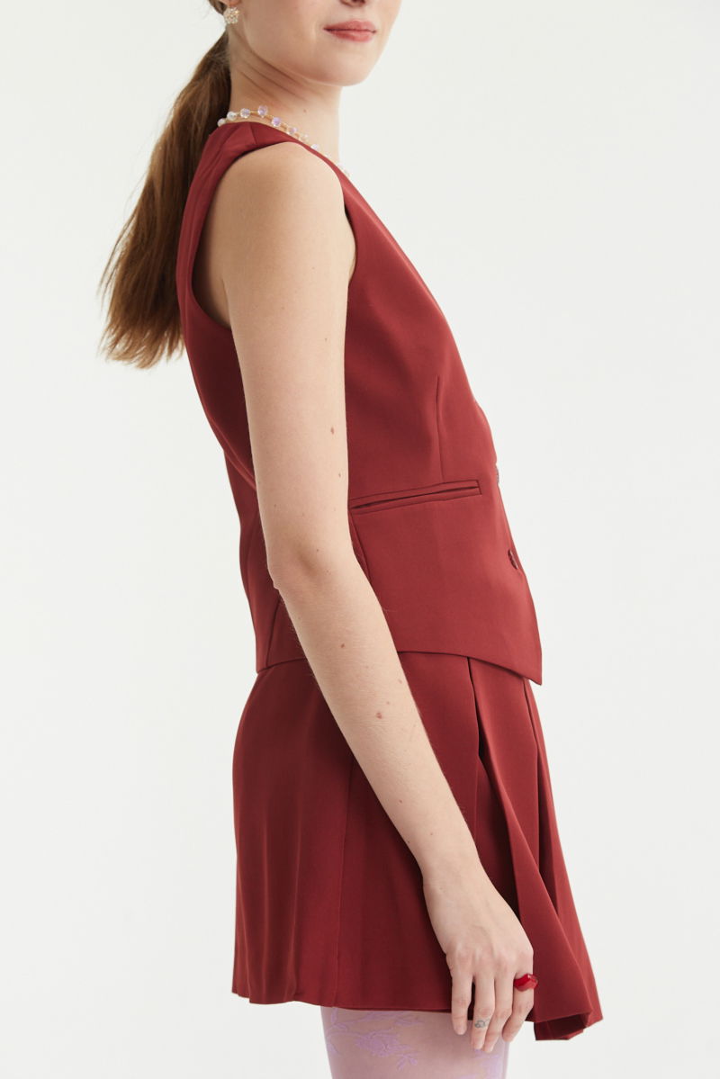 Chaleco bordo sastrero largo a la cadera con botones a tono, bolsillos ojal y pinzas en frente y espalda. 
