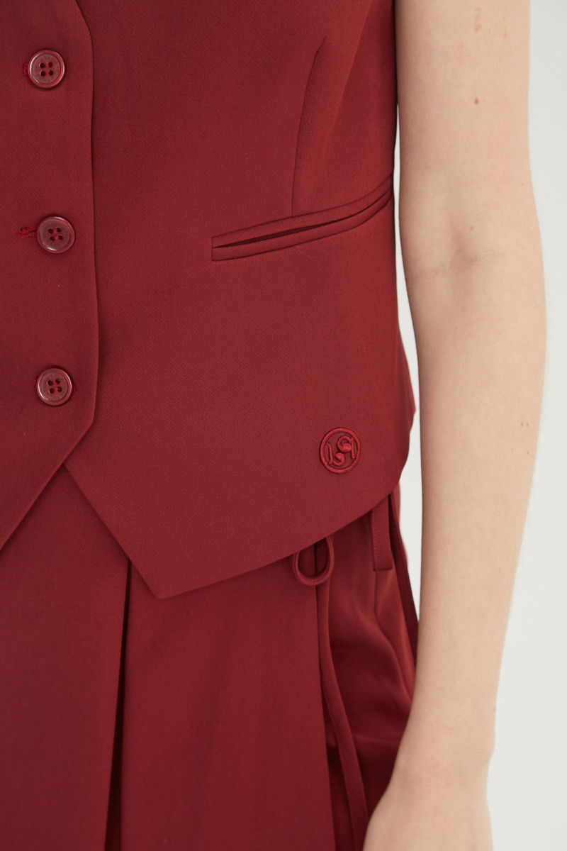 Chaleco bordo sastrero largo a la cadera con botones a tono, bolsillos ojal y pinzas en frente y espalda. 
